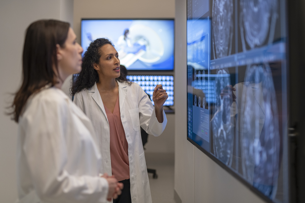Two radiologists examine scans on a lightbox
